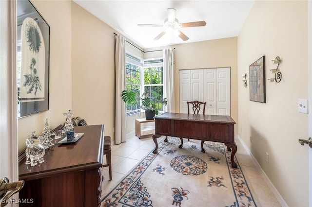 office area featuring a ceiling fan, light tile patterned flooring, and baseboards