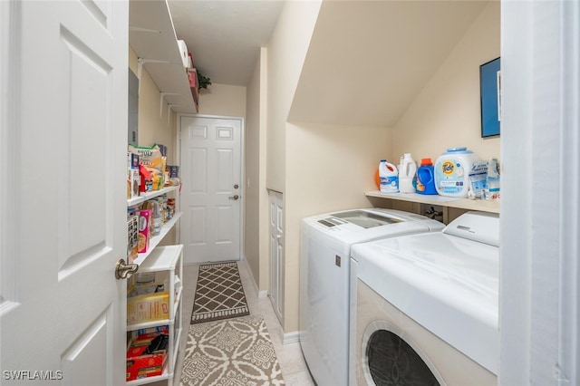 laundry room with separate washer and dryer, light tile patterned floors, and baseboards