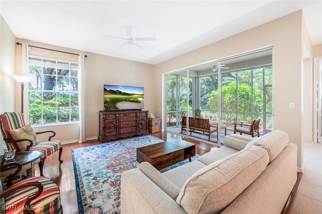 living room with a ceiling fan and baseboards