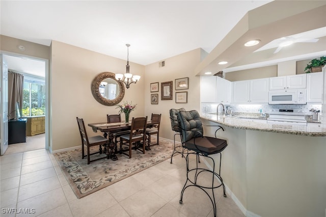 dining area with baseboards, a chandelier, recessed lighting, light tile patterned floors, and a ceiling fan