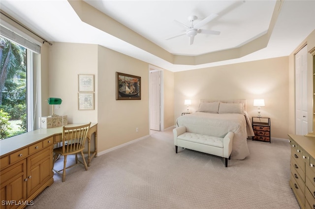 bedroom with an office area, light colored carpet, baseboards, and ceiling fan