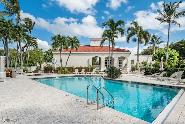 community pool featuring a patio and fence