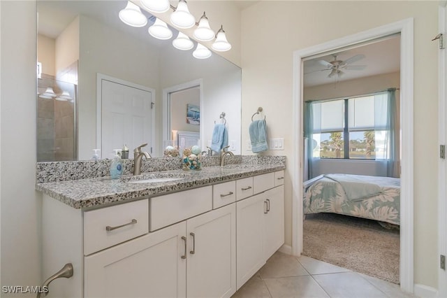bathroom with a sink, tile patterned floors, ceiling fan with notable chandelier, and double vanity