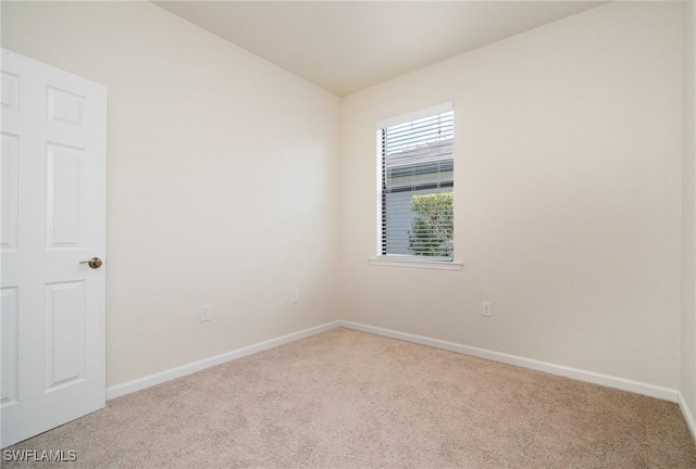 unfurnished room with carpet flooring and baseboards