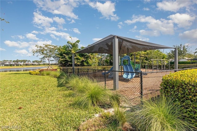 view of property's community featuring a yard, a water view, fence, and playground community