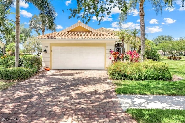 2783 Island Pond Ln, Naples, FL 34119 - ranch-style house with an attached garage, a tiled roof, stucco siding, and decorative driveway