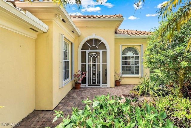 2783 Island Pond Ln, Naples, FL 34119 - property entrance with a tile roof, a patio, and stucco siding