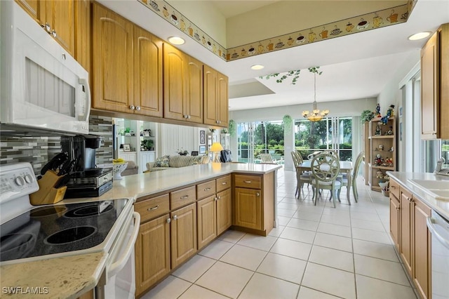 2783 Island Pond Ln, Naples, FL 34119 - kitchen with white appliances, light tile patterned floors, an inviting chandelier, light countertops, and a peninsula