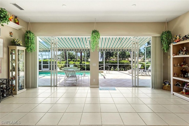 2783 Island Pond Ln, Naples, FL 34119 - doorway with light tile patterned flooring, plenty of natural light, and visible vents