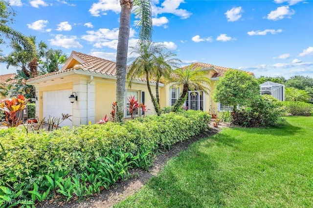 2783 Island Pond Ln, Naples, FL 34119 - mediterranean / spanish-style house featuring an attached garage, a tile roof, a front yard, and stucco siding