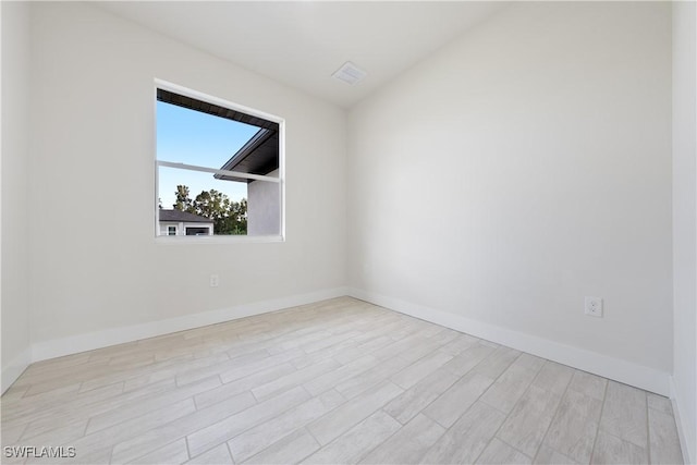 spare room featuring wood finished floors and baseboards