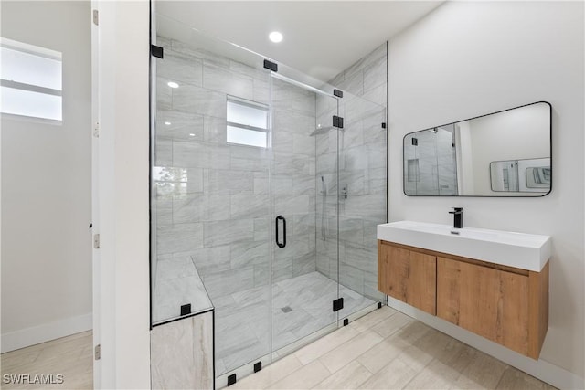 full bath featuring baseboards, plenty of natural light, vanity, and a stall shower