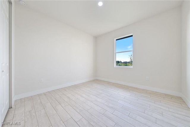 unfurnished room featuring recessed lighting, baseboards, and light wood-style flooring