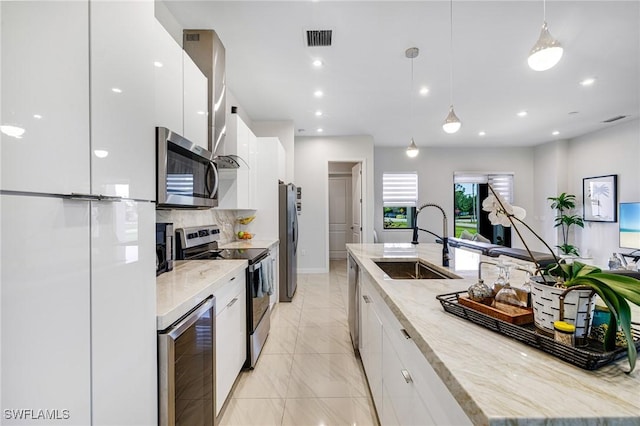 1990 47th Ave NE, Naples, FL 34120 - kitchen with stainless steel appliances, wine cooler, modern cabinets, a sink, and white cabinetry