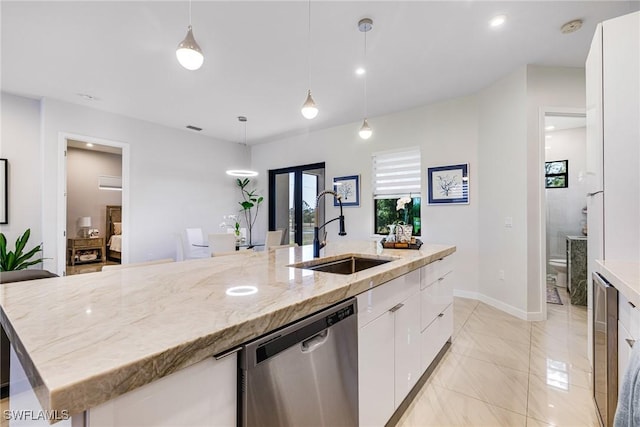 1990 47th Ave NE, Naples, FL 34120 - kitchen featuring white cabinetry, stainless steel dishwasher, a large island with sink, and a sink