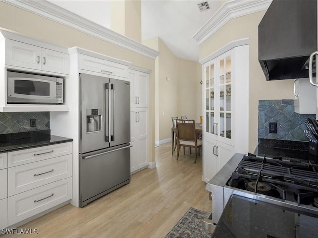 kitchen with ventilation hood, visible vents, backsplash, and appliances with stainless steel finishes