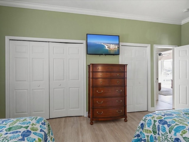 bedroom featuring light wood-style floors, crown molding, and baseboards