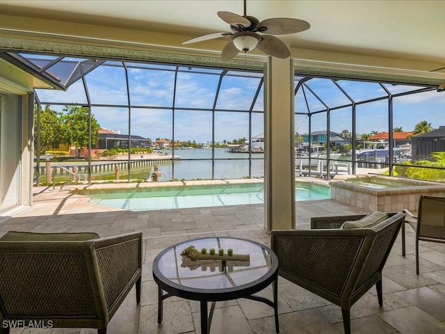view of swimming pool featuring a patio area, glass enclosure, and a water view