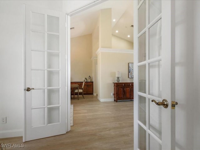 hall featuring wood finished floors, french doors, baseboards, and high vaulted ceiling
