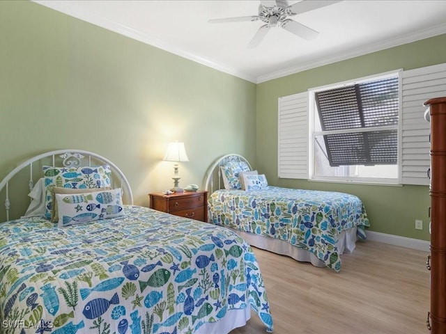 bedroom featuring wood finished floors, crown molding, baseboards, and a ceiling fan