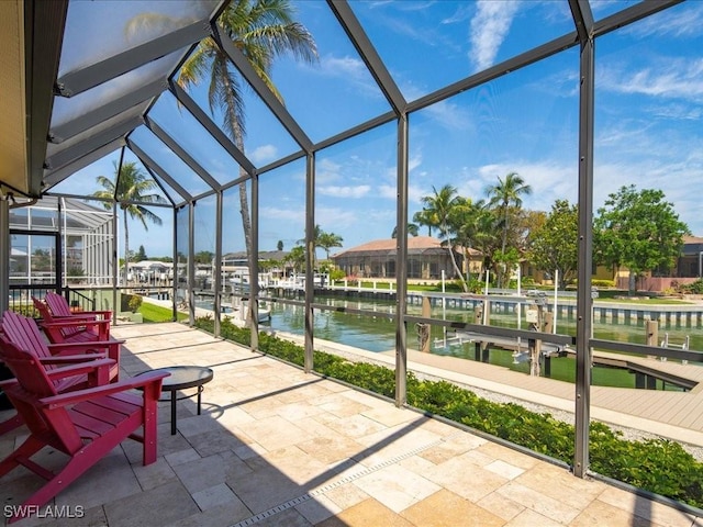 view of patio / terrace with glass enclosure and a water view