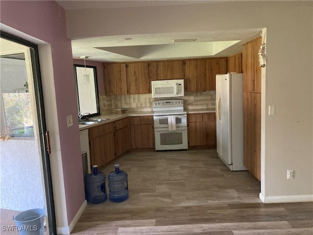 191 Round Key Cir Unit D2, Naples, FL 34112 - kitchen with white appliances, light countertops, backsplash, brown cabinets, and light wood finished floors