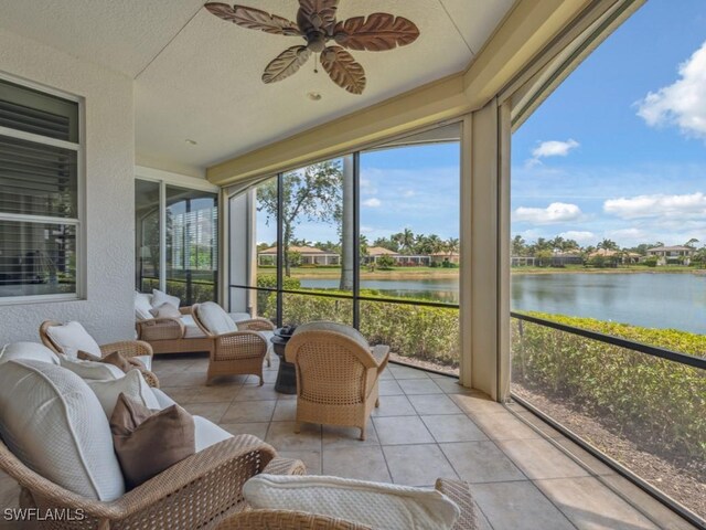 28561 Calabria Ct Unit 102, Naples, FL 34110 - sunroom with a water view, a ceiling fan, tile patterned floors, a textured wall, and outdoor lounge area