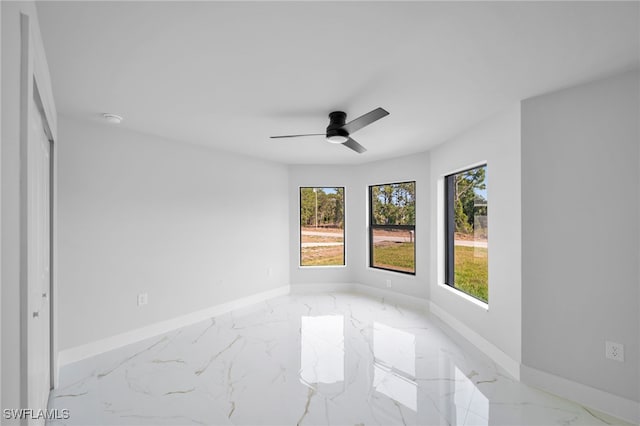 2603 36th St SW, Lehigh Acres, FL 33976 - spare room featuring light marble finish flooring, baseboards, ceiling fan, and a smoke detector