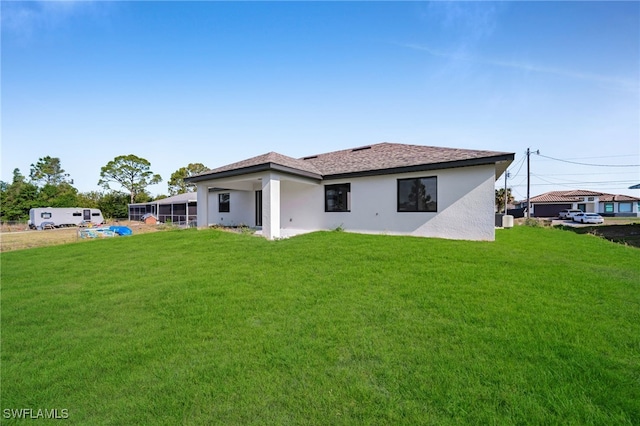 2603 36th St SW, Lehigh Acres, FL 33976 - rear view of house with stucco siding and a yard