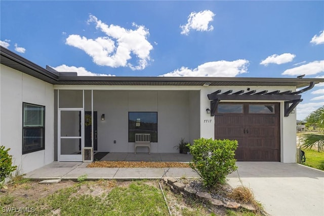 7717 16th Ter, Labelle, FL 33935 - view of exterior entry featuring a garage, stucco siding, and concrete driveway
