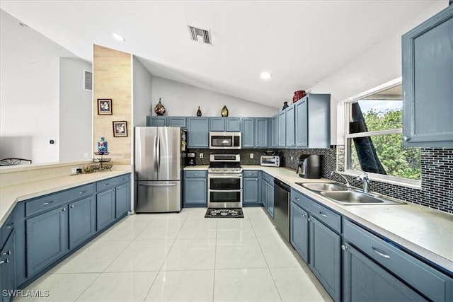 167 Pembroke St, Lehigh Acres, FL 33974 - kitchen with appliances with stainless steel finishes, a sink, decorative backsplash, vaulted ceiling, and visible vents