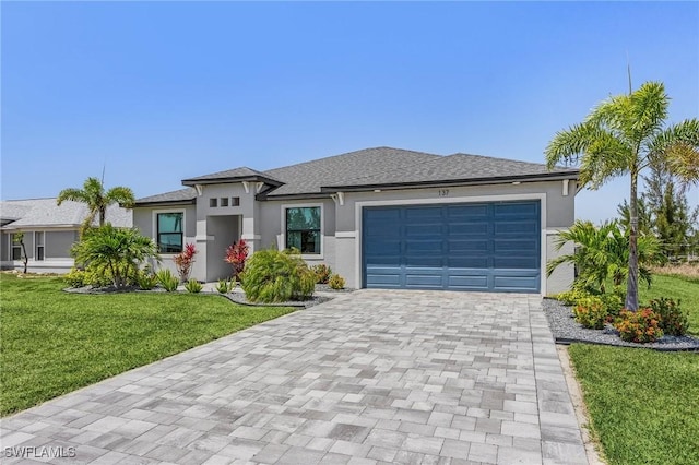 137 SE 23rd Ter, Cape Coral, FL 33990 - prairie-style house with a garage, stucco siding, a front yard, and decorative driveway