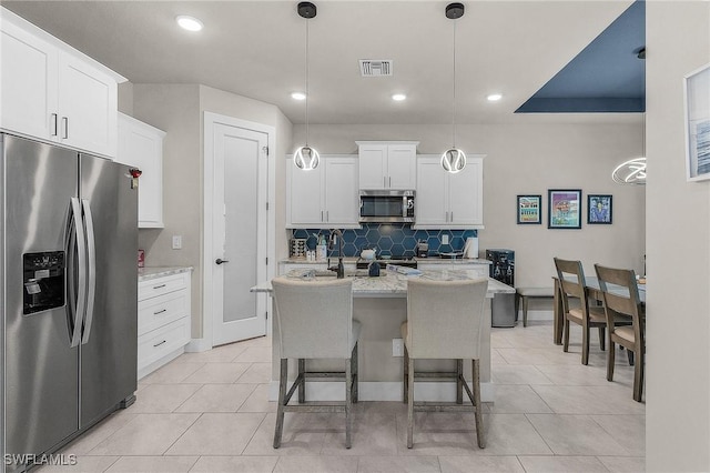 137 SE 23rd Ter, Cape Coral, FL 33990 - kitchen featuring tasteful backsplash, hanging light fixtures, stainless steel appliances, white cabinetry, and visible vents