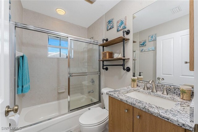 24343 Pirate Harbor Blvd, Punta Gorda, FL 33955 - bathroom featuring visible vents, vanity, shower / bath combination with glass door, and toilet