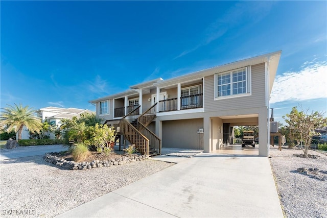 24343 Pirate Harbor Blvd, Punta Gorda, FL 33955 - beach home featuring stairway, concrete driveway, stucco siding, a carport, and a porch