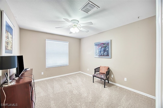 living area featuring carpet, visible vents, baseboards, and ceiling fan
