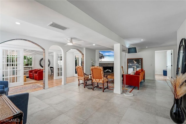 interior space featuring arched walkways, baseboards, recessed lighting, and visible vents
