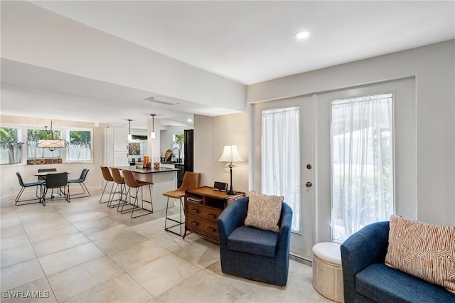 living room with visible vents, baseboards, and light tile patterned floors