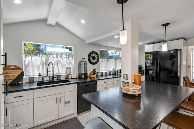 kitchen with a sink, dark countertops, black appliances, and a wealth of natural light