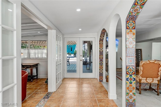 tiled foyer with stairway, arched walkways, french doors, and recessed lighting