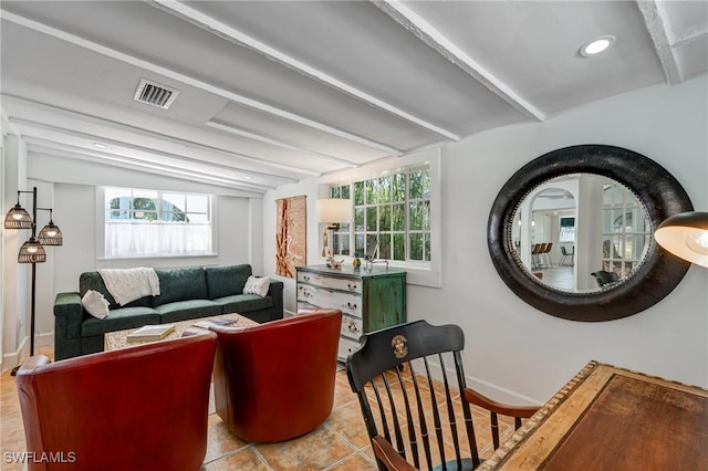 living area featuring visible vents, baseboards, tile patterned flooring, and beamed ceiling