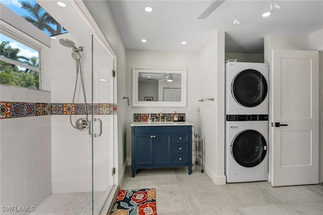 full bathroom featuring stacked washer and dryer, a ceiling fan, recessed lighting, baseboards, and a shower stall