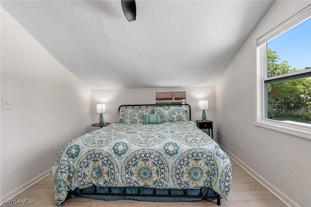 bedroom featuring baseboards and light wood finished floors