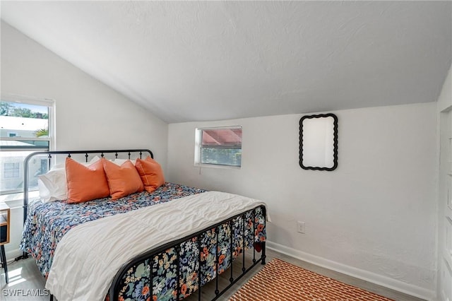 bedroom featuring baseboards and vaulted ceiling