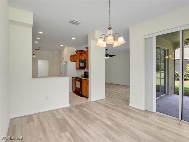 20298 Larino Loop, Estero, FL 33928 - kitchen with black appliances, a chandelier, light wood-style floors, baseboards, and brown cabinetry