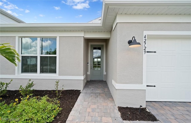 42729 Valley Brooks St, Punta Gorda, FL 33982 - view of exterior entry with stucco siding and an attached garage