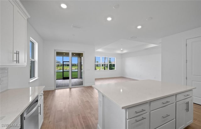 42729 Valley Brooks St, Punta Gorda, FL 33982 - kitchen with stainless steel dishwasher, open floor plan, light wood-style flooring, white cabinets, and recessed lighting