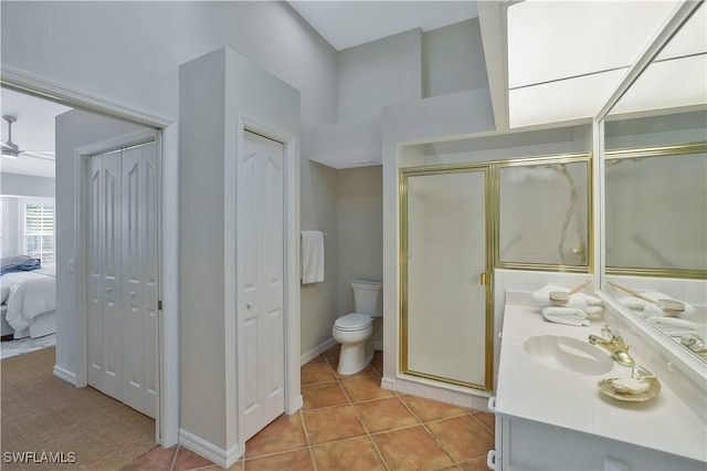 ensuite bathroom with tile patterned flooring, vanity, a closet, a stall shower, and ceiling fan
