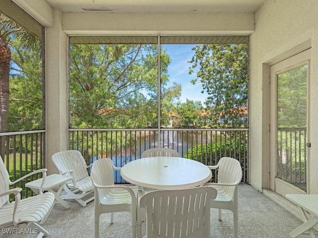 1036 Egrets Walk Cir Unit 202, Naples, FL 34108 - sunroom / solarium with a water view, plenty of natural light, and outdoor dining space