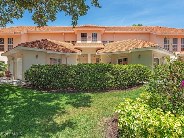 1036 Egrets Walk Cir Unit 202, Naples, FL 34108 - view of front facade featuring stucco siding, a tile roof, a front yard, and a garage
